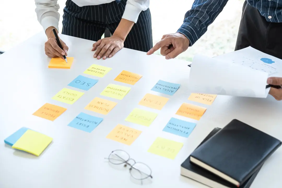 デスクに貼り付けたメモを見ながら打ち合わせ